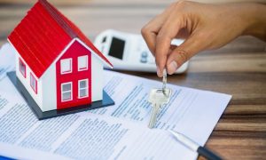 landlord places keys on paperwork that represents a tenant’s application and rental history check