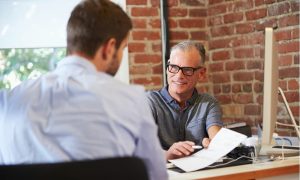 A landlord who is starting a property management company meets with a prospective renter.