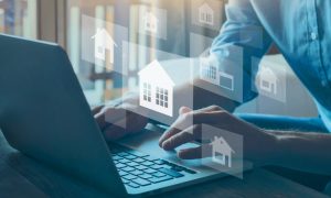 A real estate agent works on a laptop toward starting a property management business.