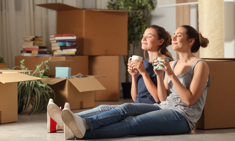 Two roommates sip coffee during their moving day as they launch a co-tenancy relationship.