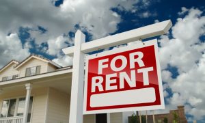 A landlord thinks about how to find good tenants after hanging up a for rent sign.